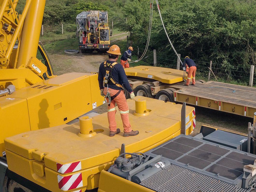 Técnicos con equipo de protección preparando una maniobra industrial